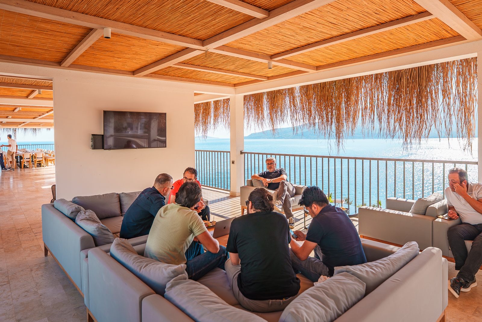 A team talking in a shaded lounge above the sea